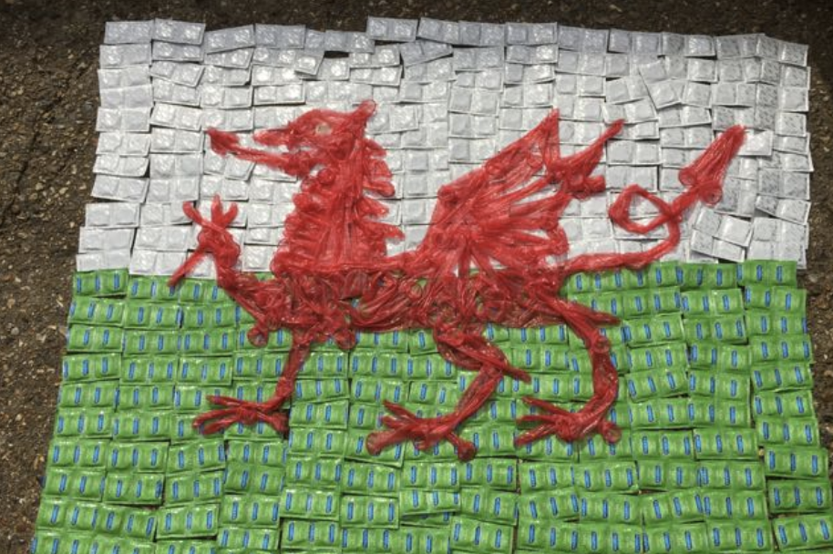 The Wales flag with dragon made out of condoms and condom packs