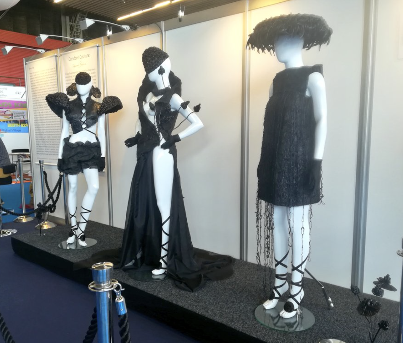 Mannequins wearing shorts, a minidress, and a gown, along with hats, made out of condoms