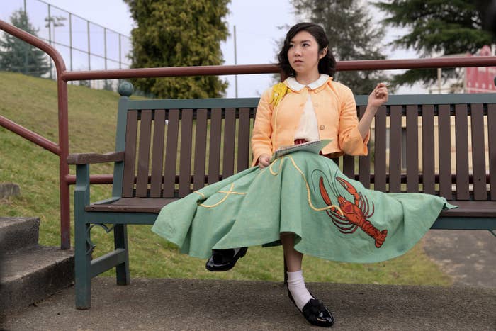Nancy Nakagawa wearing a vintage outfit sitting on a bench