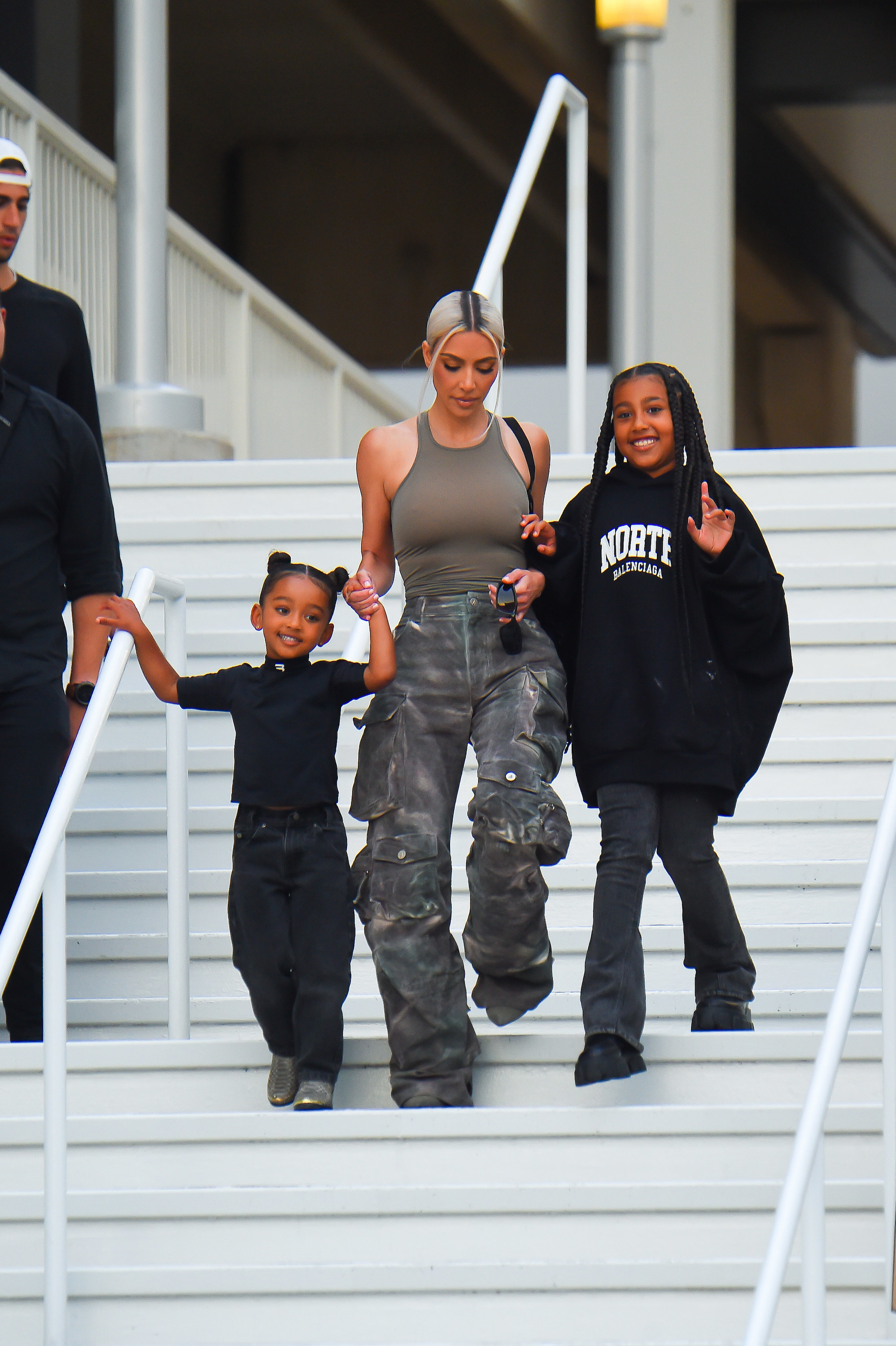 Kim walking down stairs with two of her kids