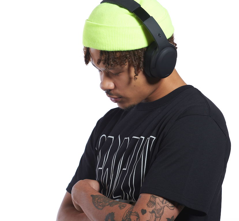 A man wearing large black Skullcandy headphones
