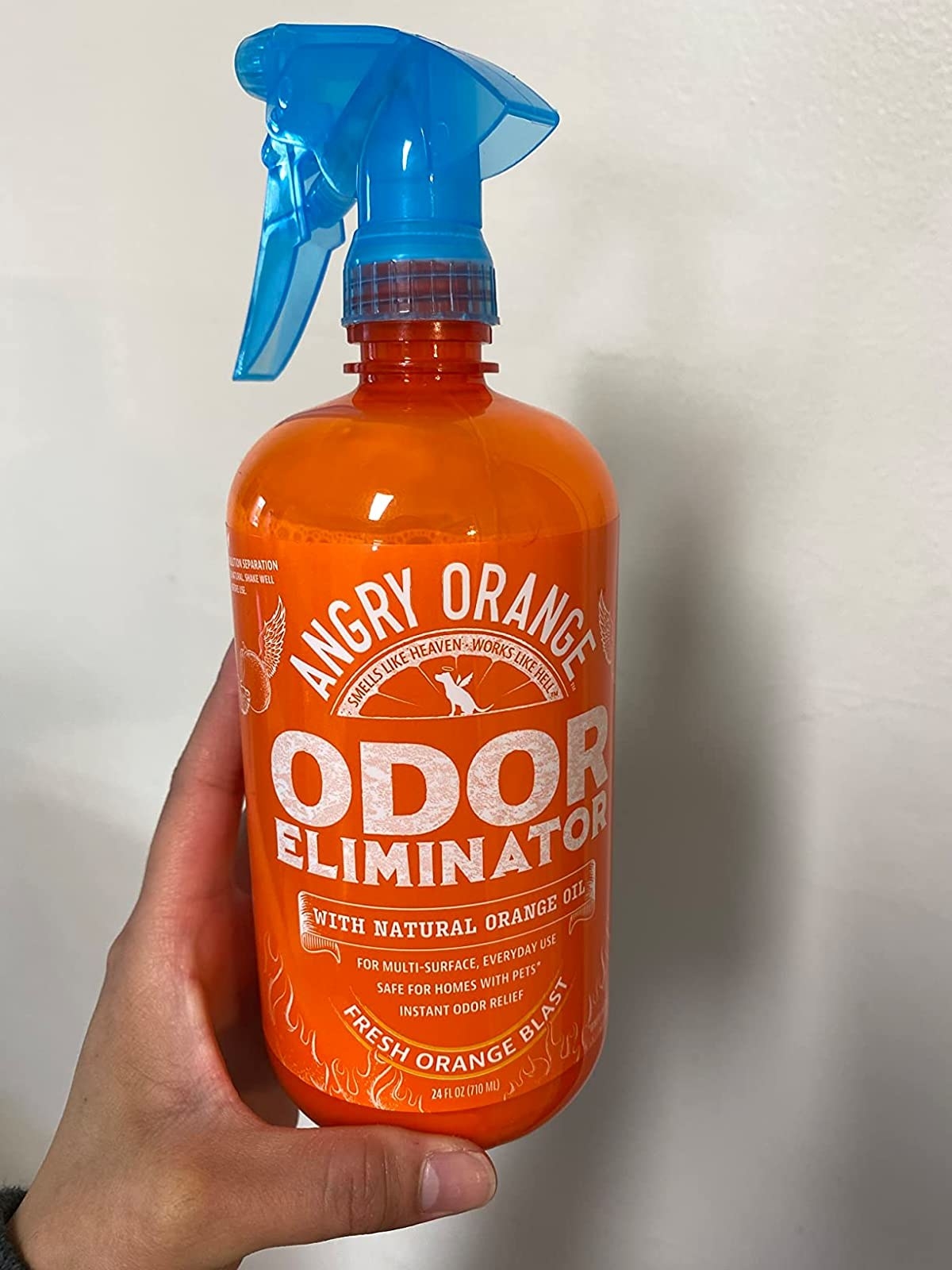 reviewer holding the Angry Orange spray bottle