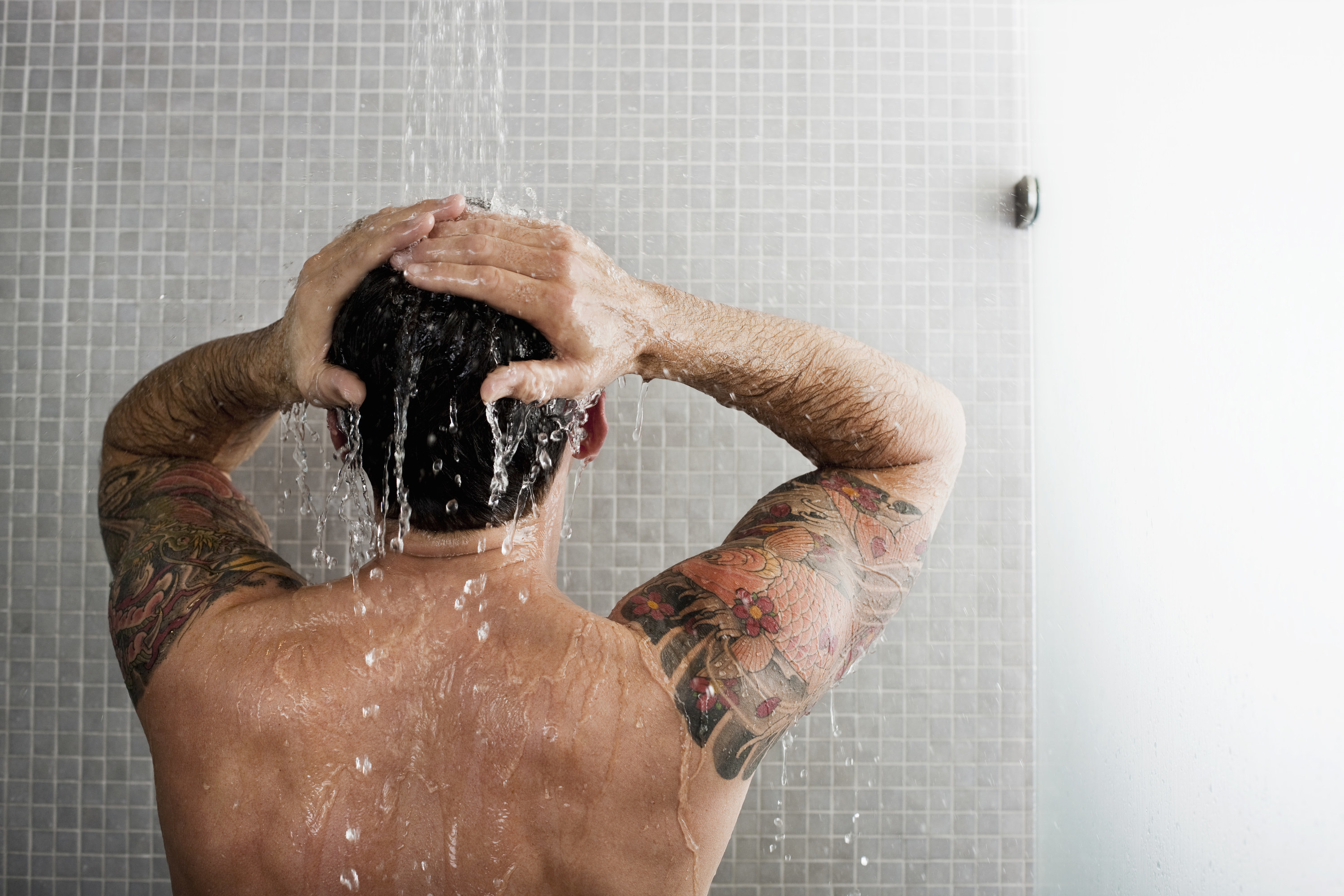 a man in the shower washing his hair