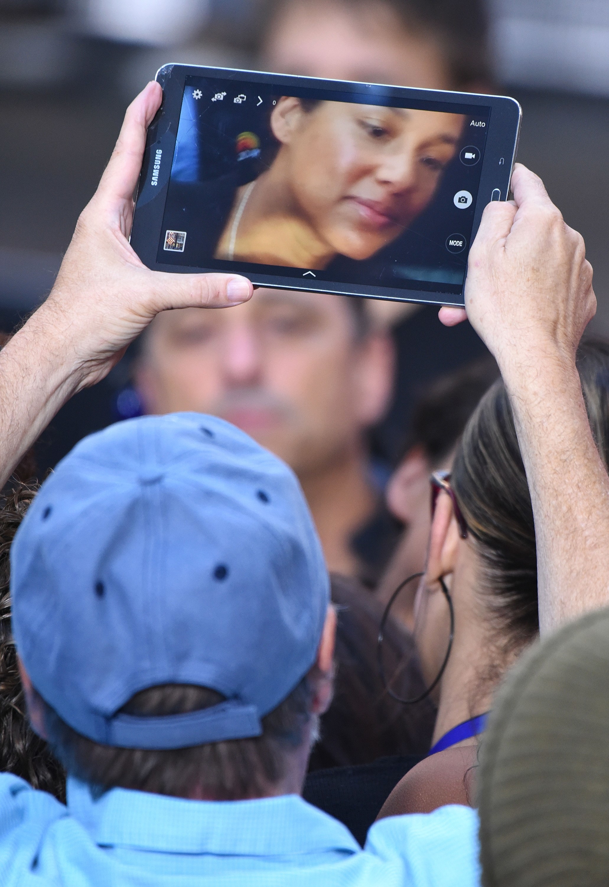 Someone in a crowd holding up an iPad