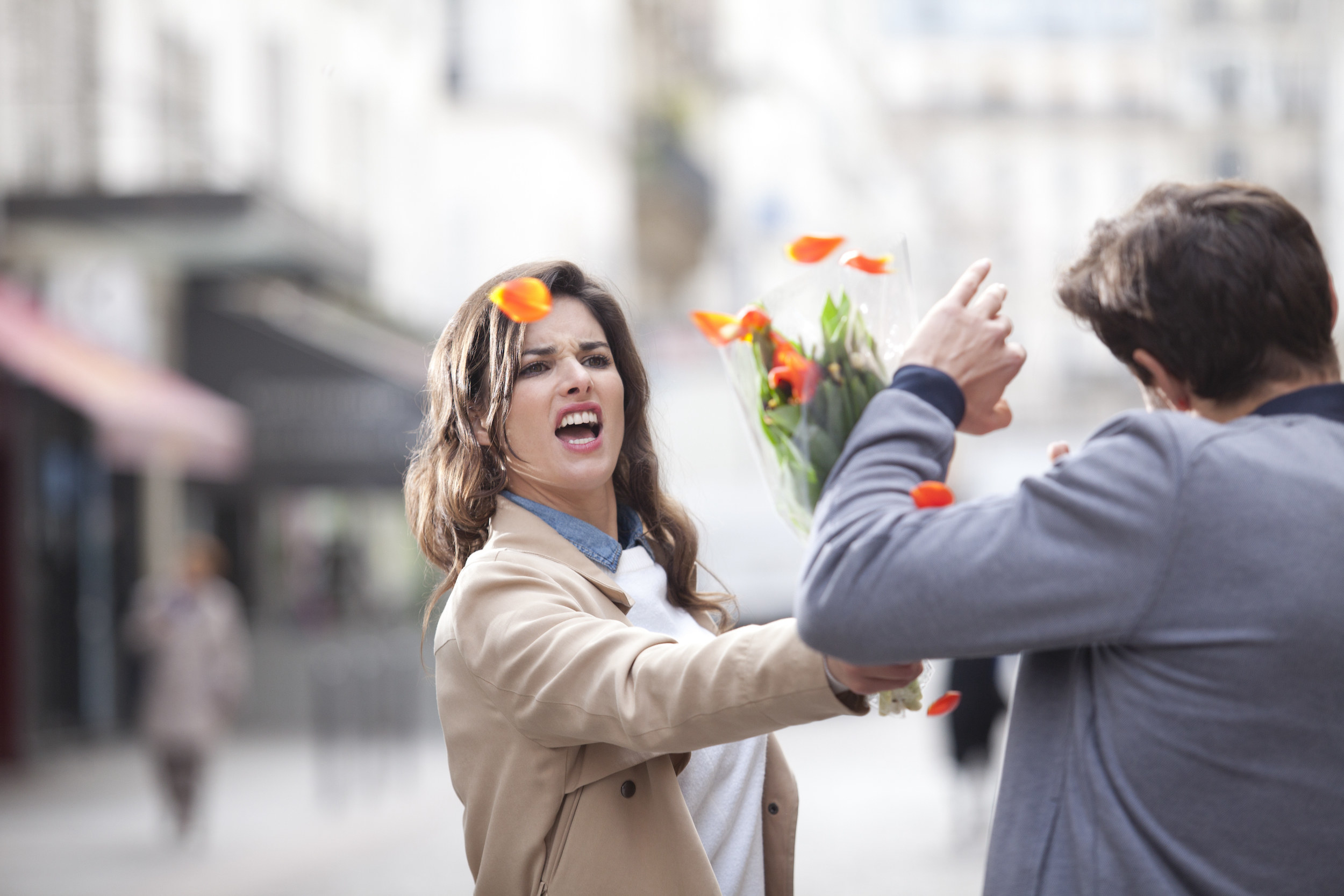 A woman hitting a man with flowers