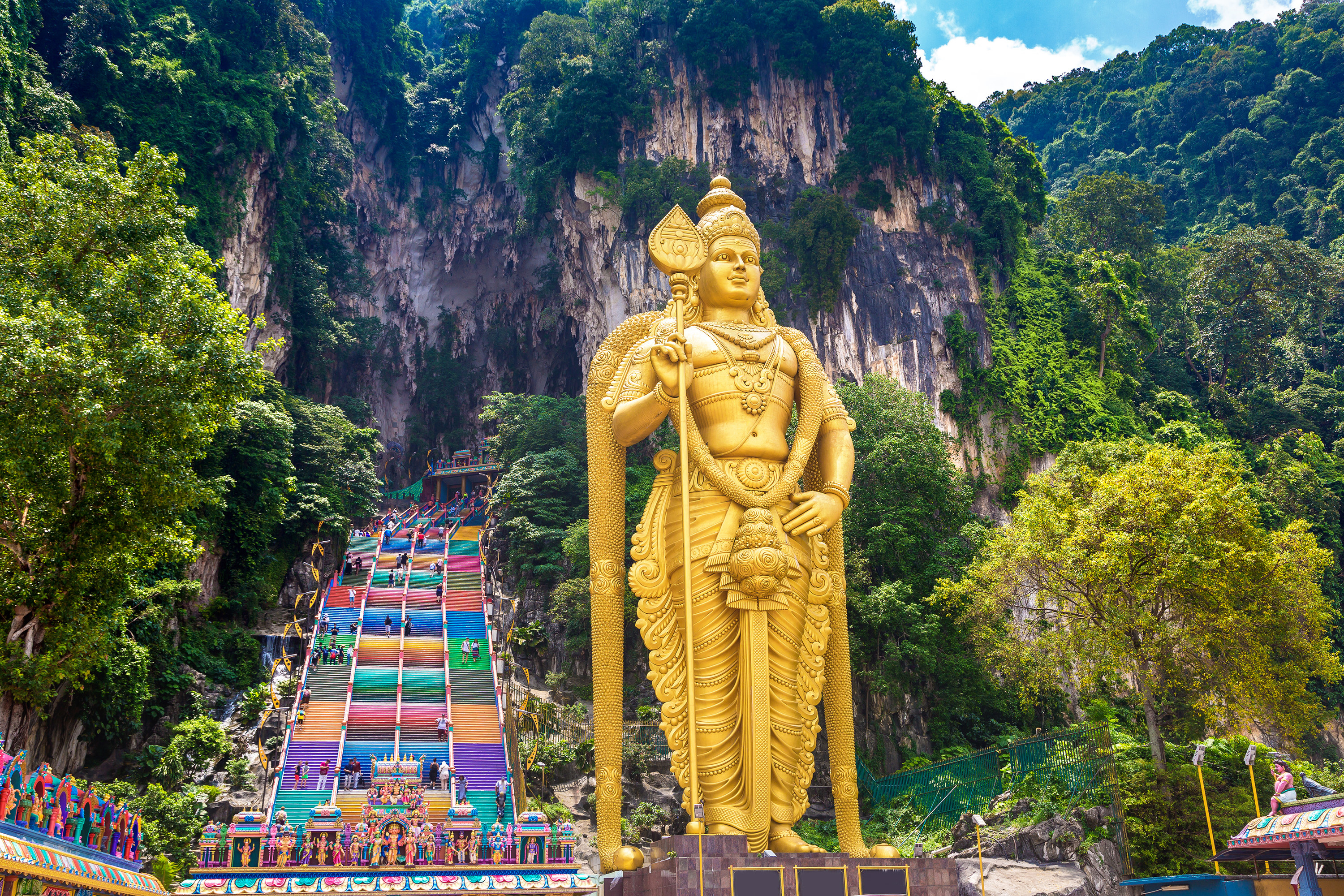 Giant gold Buddha in front of towering mountains