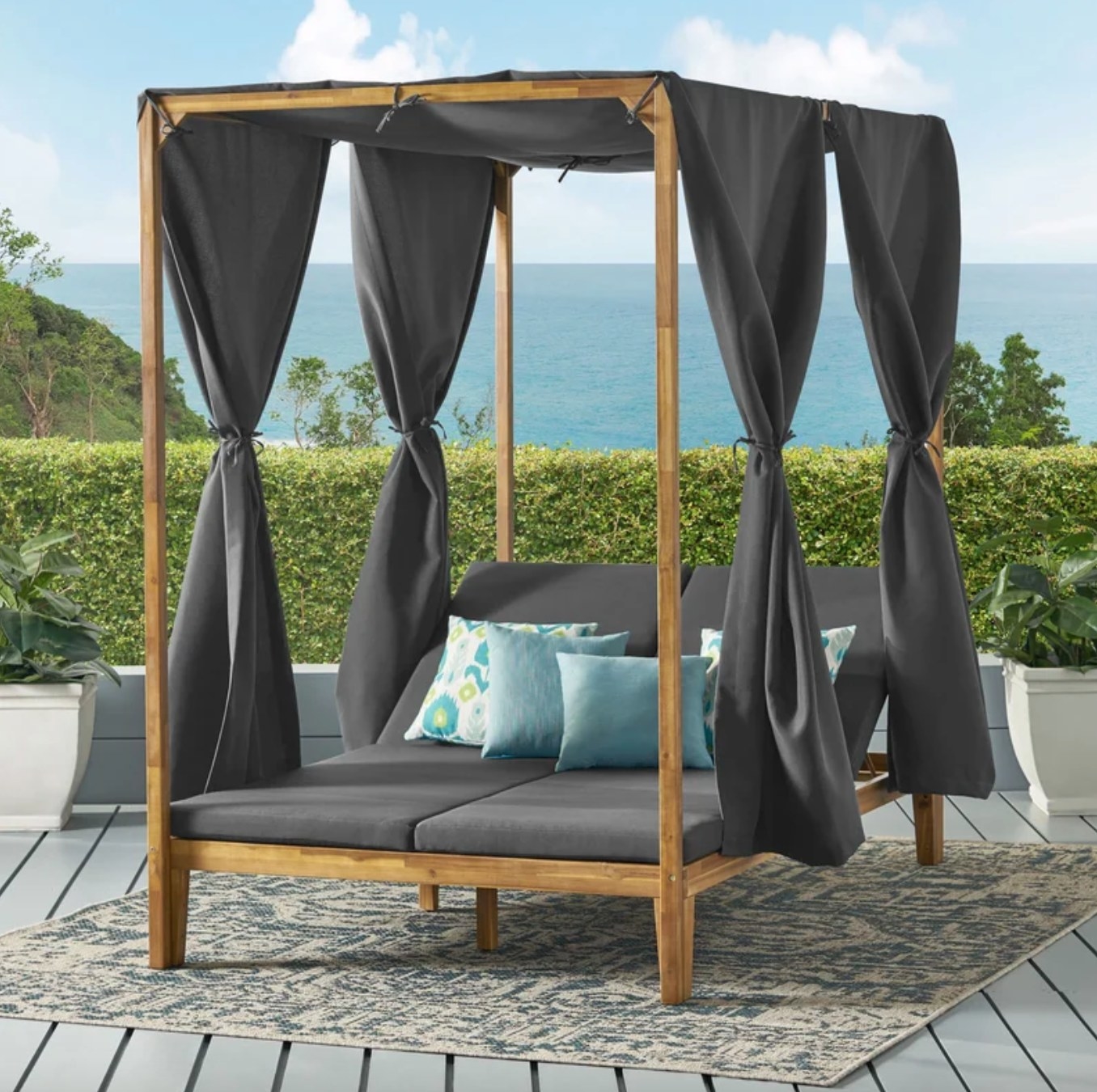 the wooden daybed with grey cushions and hangings