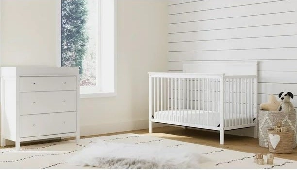 A white crib in a white room