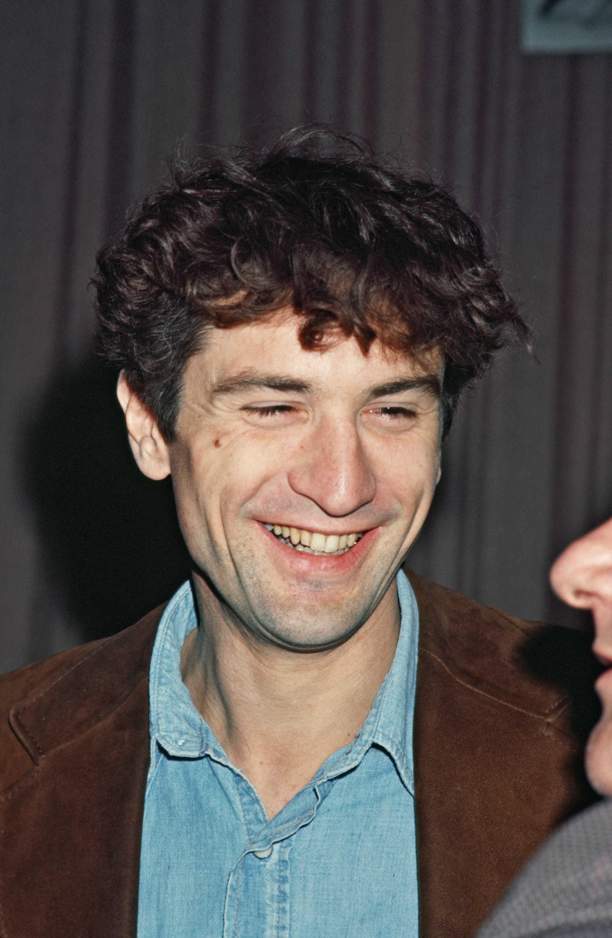 De Niro in a jean shirt and brown jacket