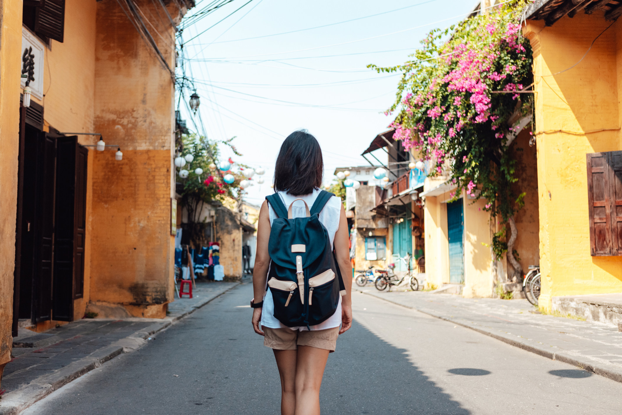 A young woman traveler walking on a quiet street with a backpack