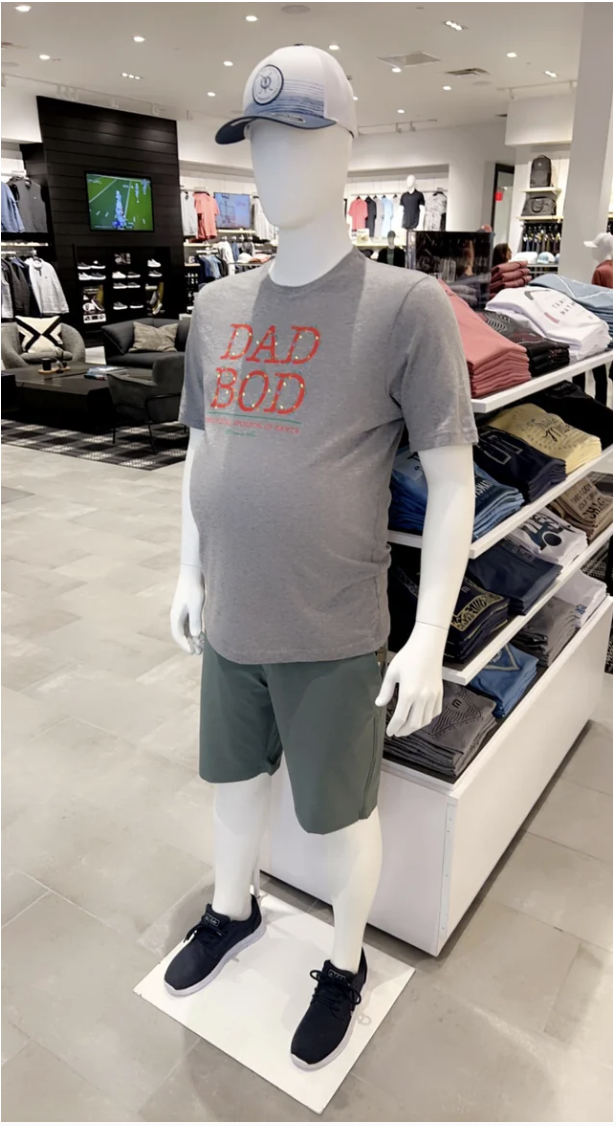 A mannequin with a gut wearing a &quot;Dad Bod&quot; T-shirt, knee-length shorts, and cap