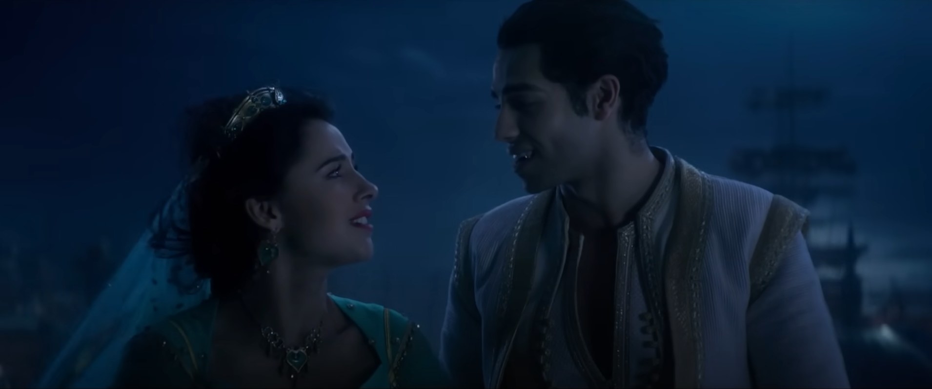 Jasmine and Aladdin from Disney&#x27;s movie look at each other, smiling, in a night scene. Jasmine wears a headband, Aladdin a vest
