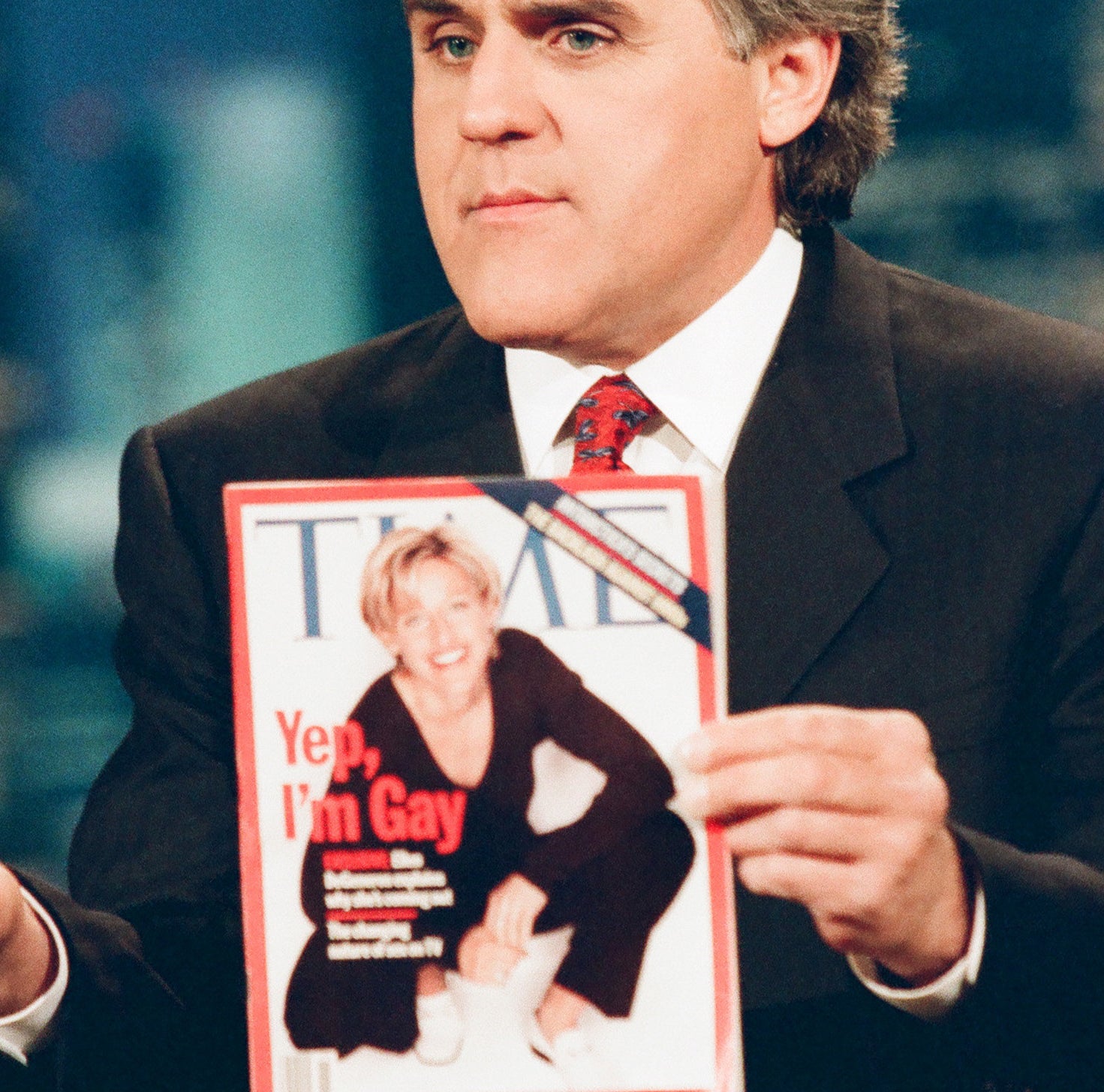A man holds the cover of a Time magazine, which shows Ellen DeGeneres squatting and the text &quot;Yep, I&#x27;m Gay&quot;