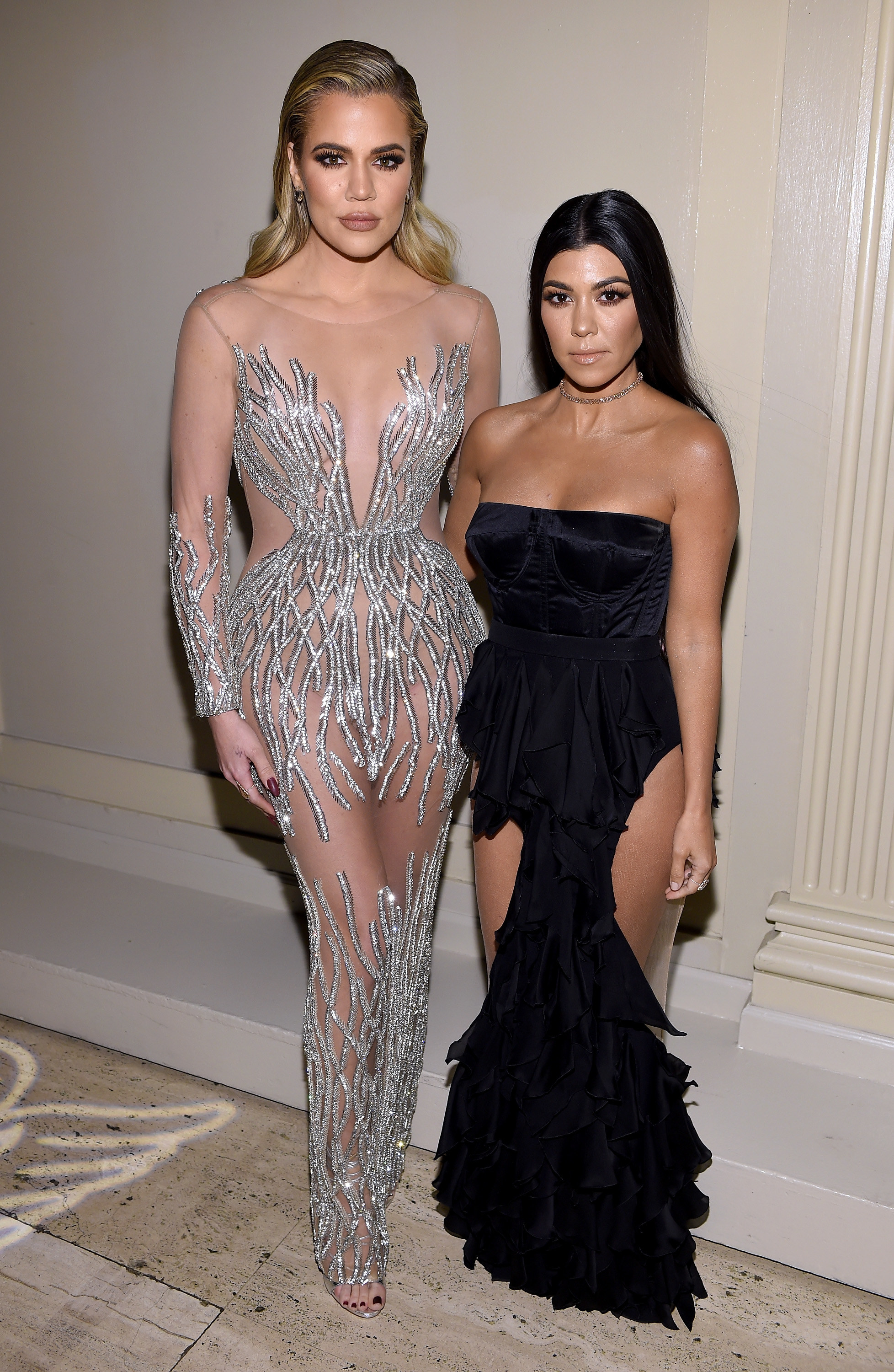 Khloé and Kourtney standing together and looking serious