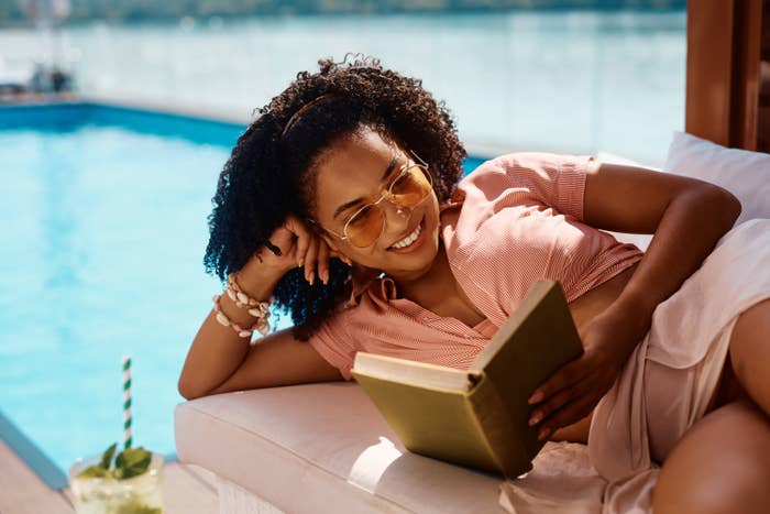 a woman reading a book by the pool