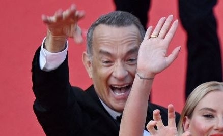 Closeup of Tom Hanks smiling and waving