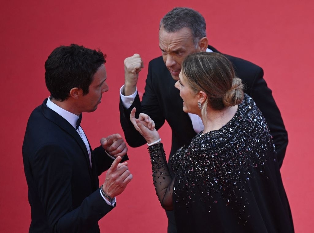 A man speaking with Tom Hanks and Rita Wilson