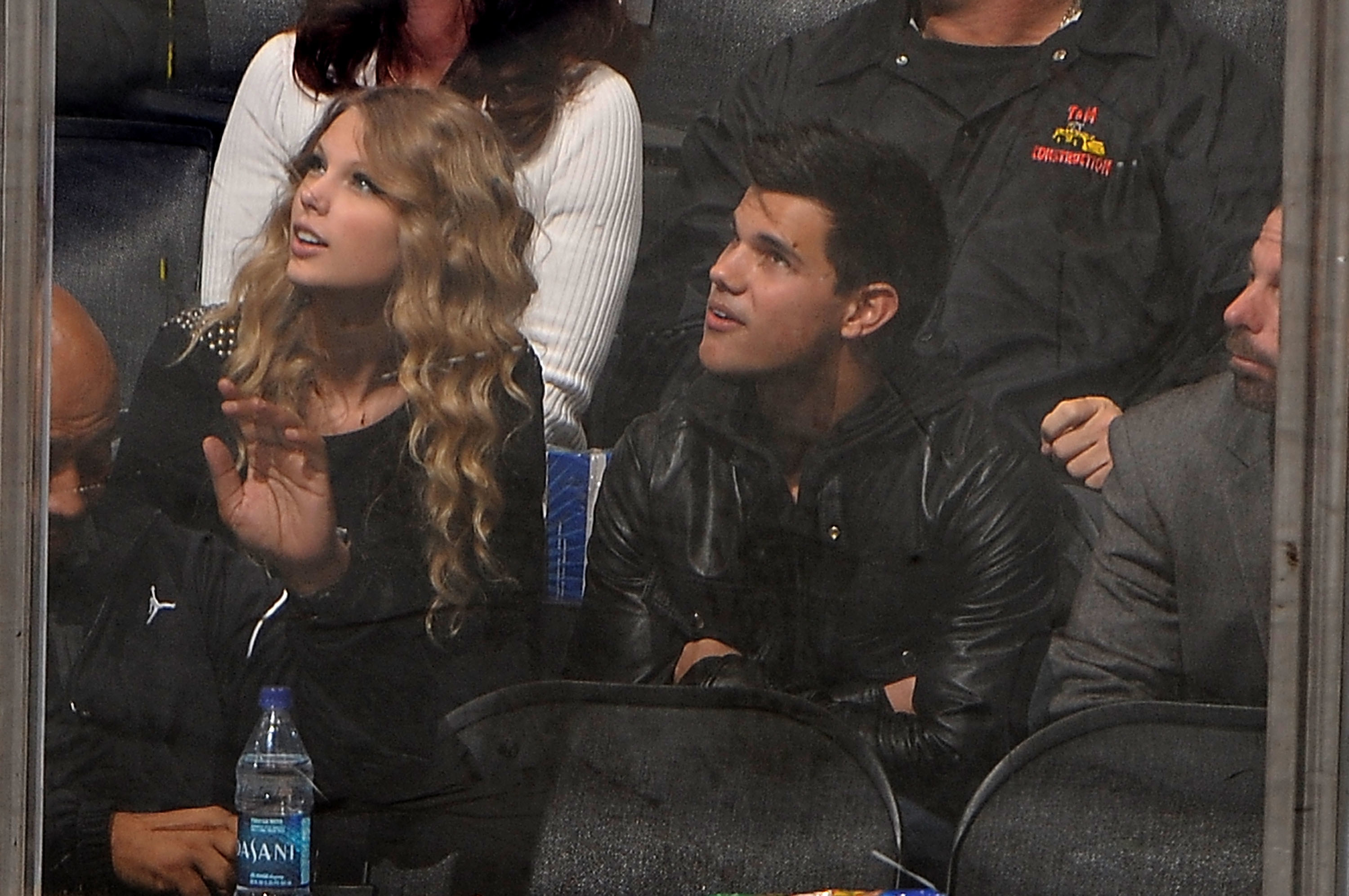 Taylor Swift and Taylor Lautner sitting next to each other at an event