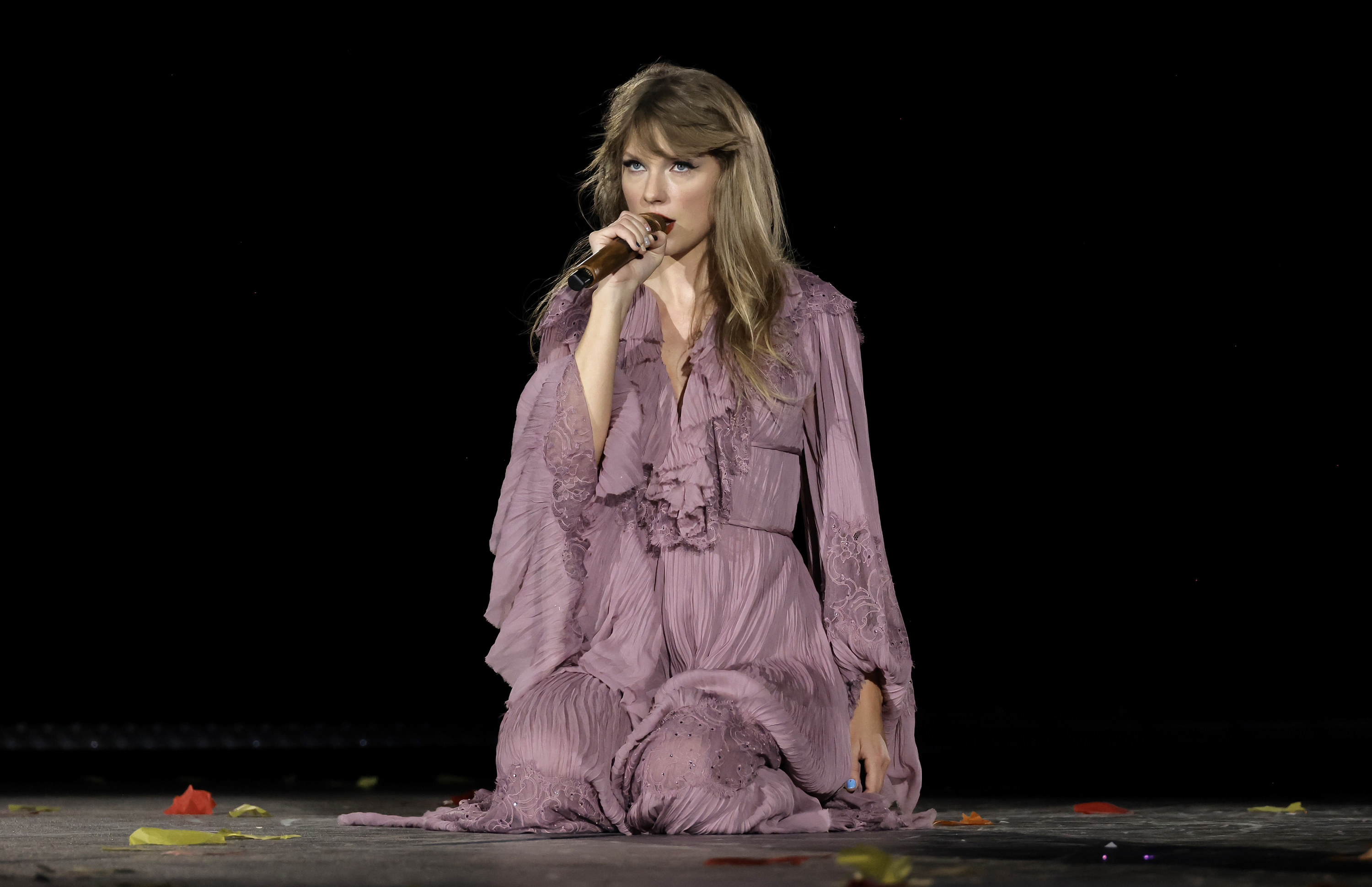 Taylor on her knees singing onstage