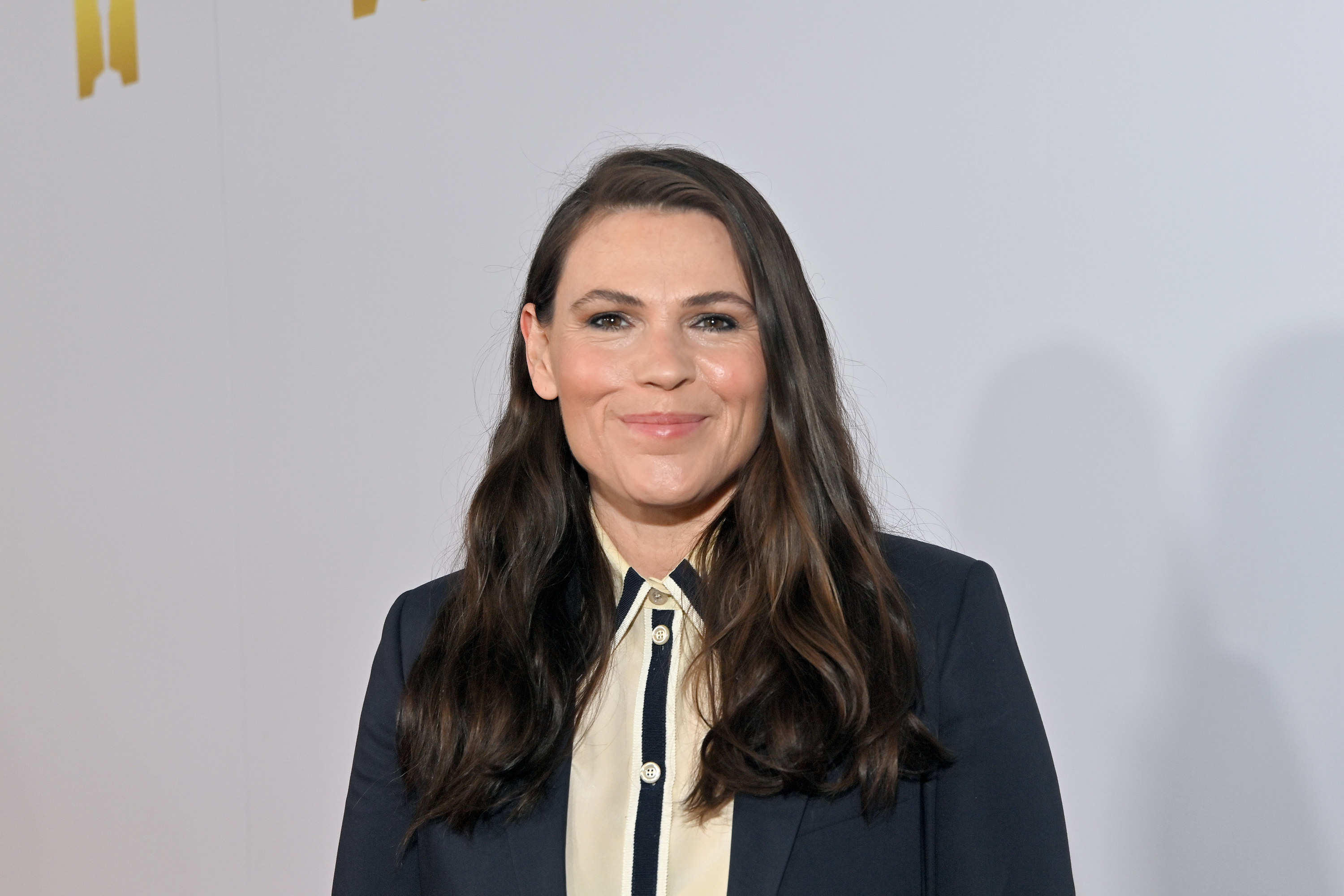 Clea DuVall poses in a black blazer and white button-up shirt