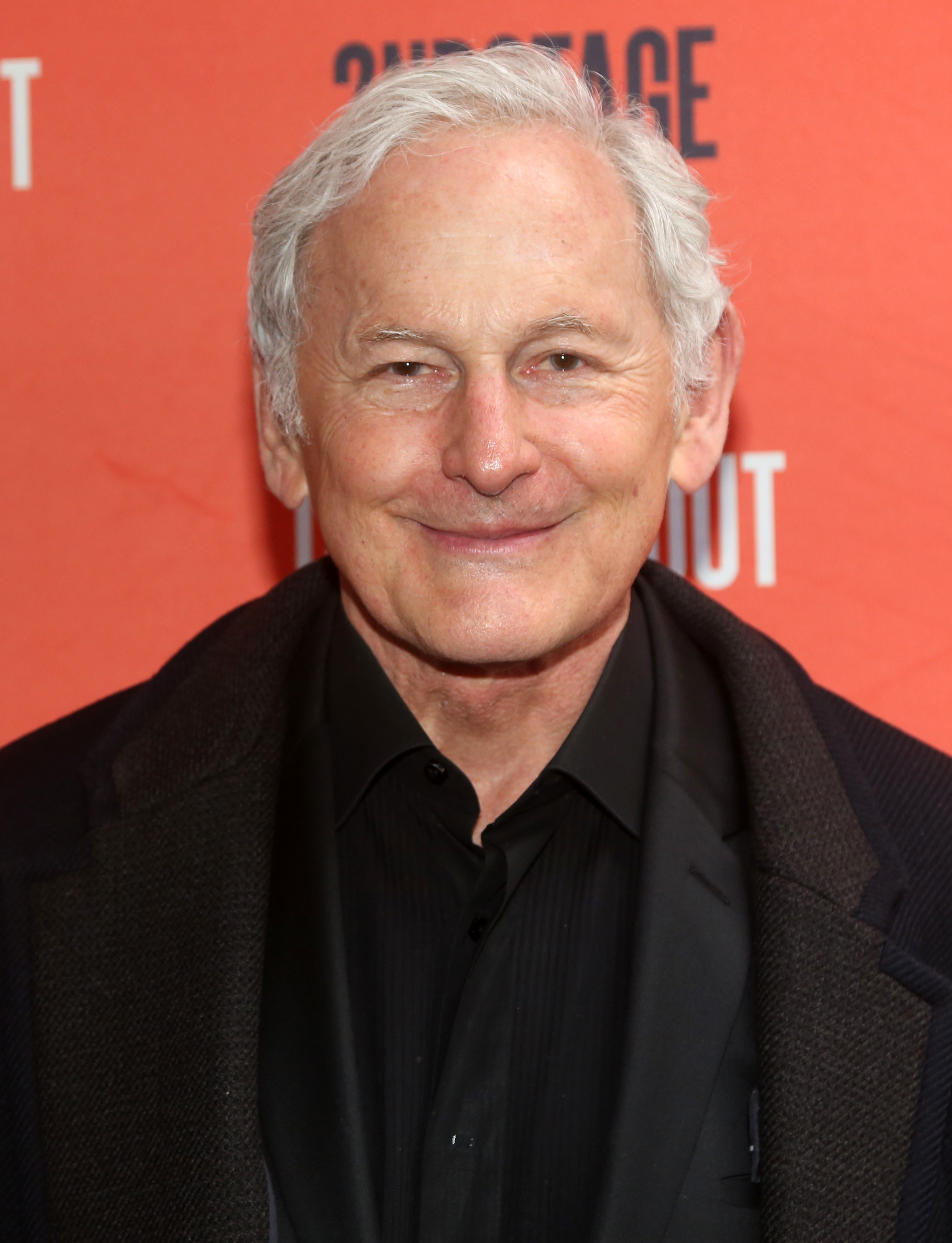 Victor Garber wearing all-black posing at an event
