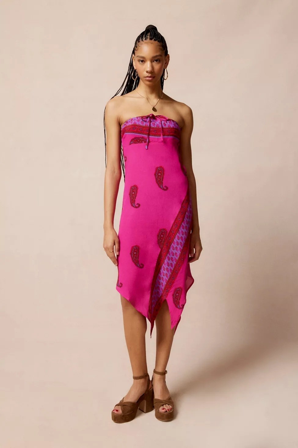 Model wearing strapless hot pink paisley midi dress with pointed hemline