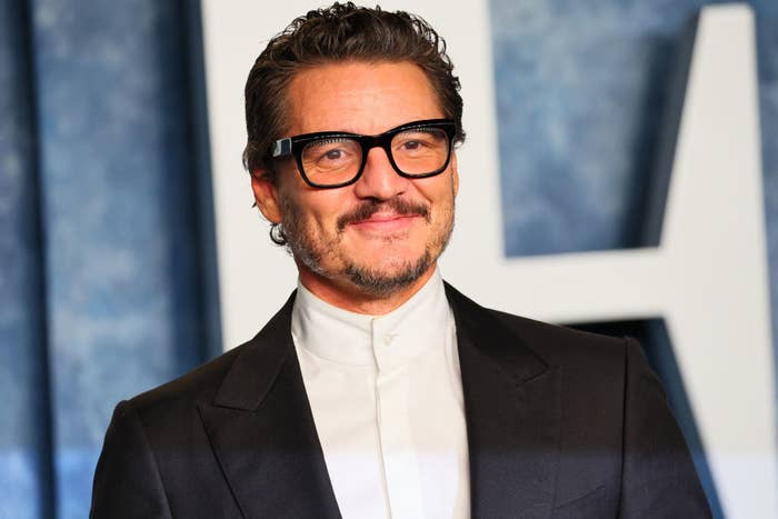 A closeup of Pedro Pascal at a red carpet event wearing eyeglasses