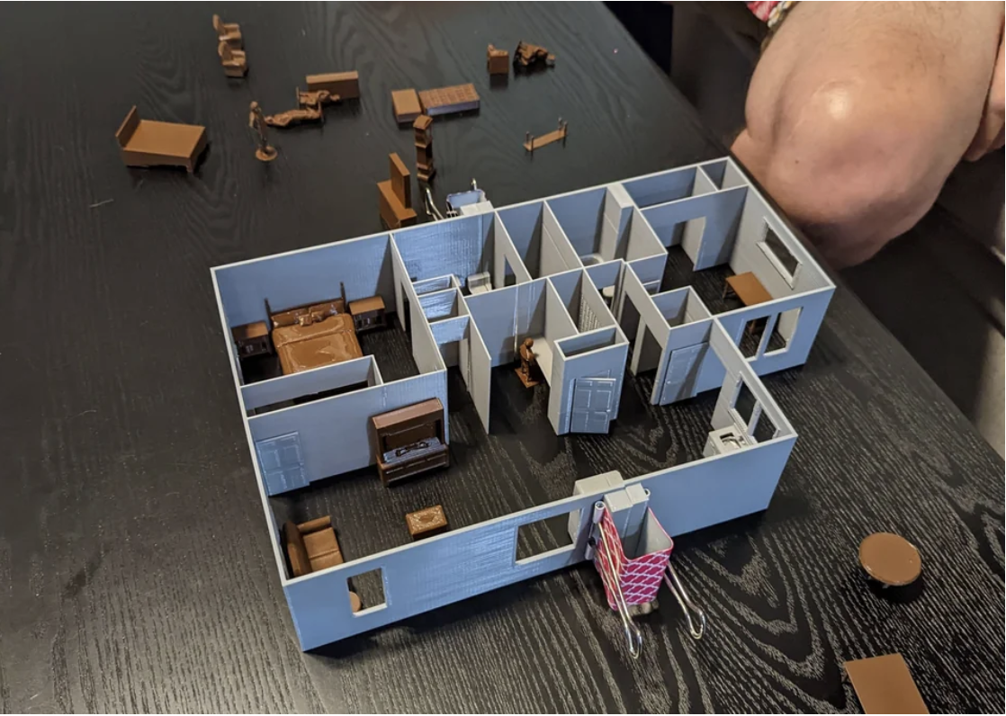 Scale model of a floor plan with furniture and person