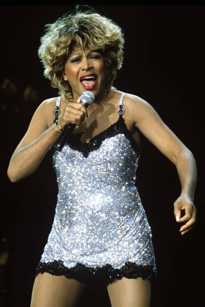 A closeup of Tina singing while wearing a short sequined dress