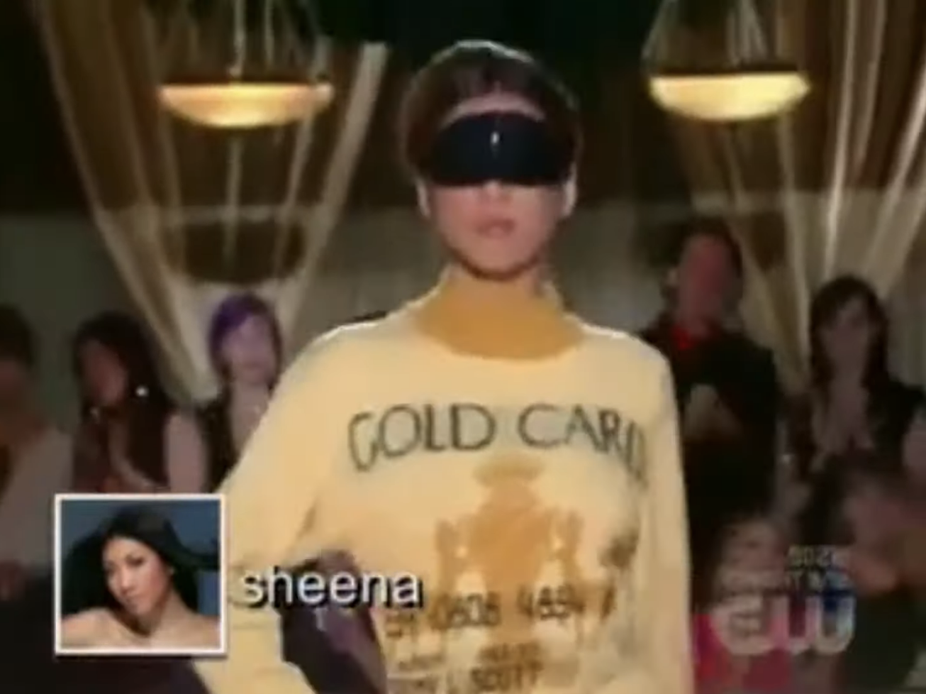 A contestant walks down the runway blindfolded