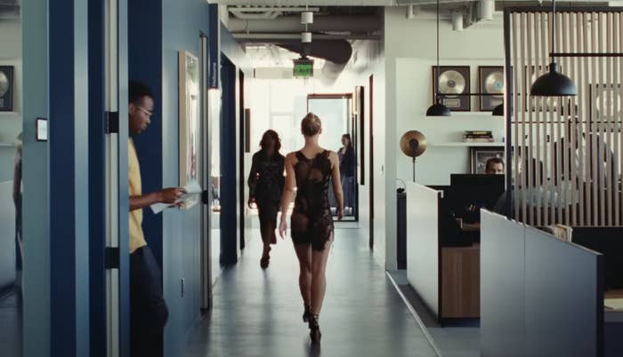 A shot of a woman walking down the hallway of an office