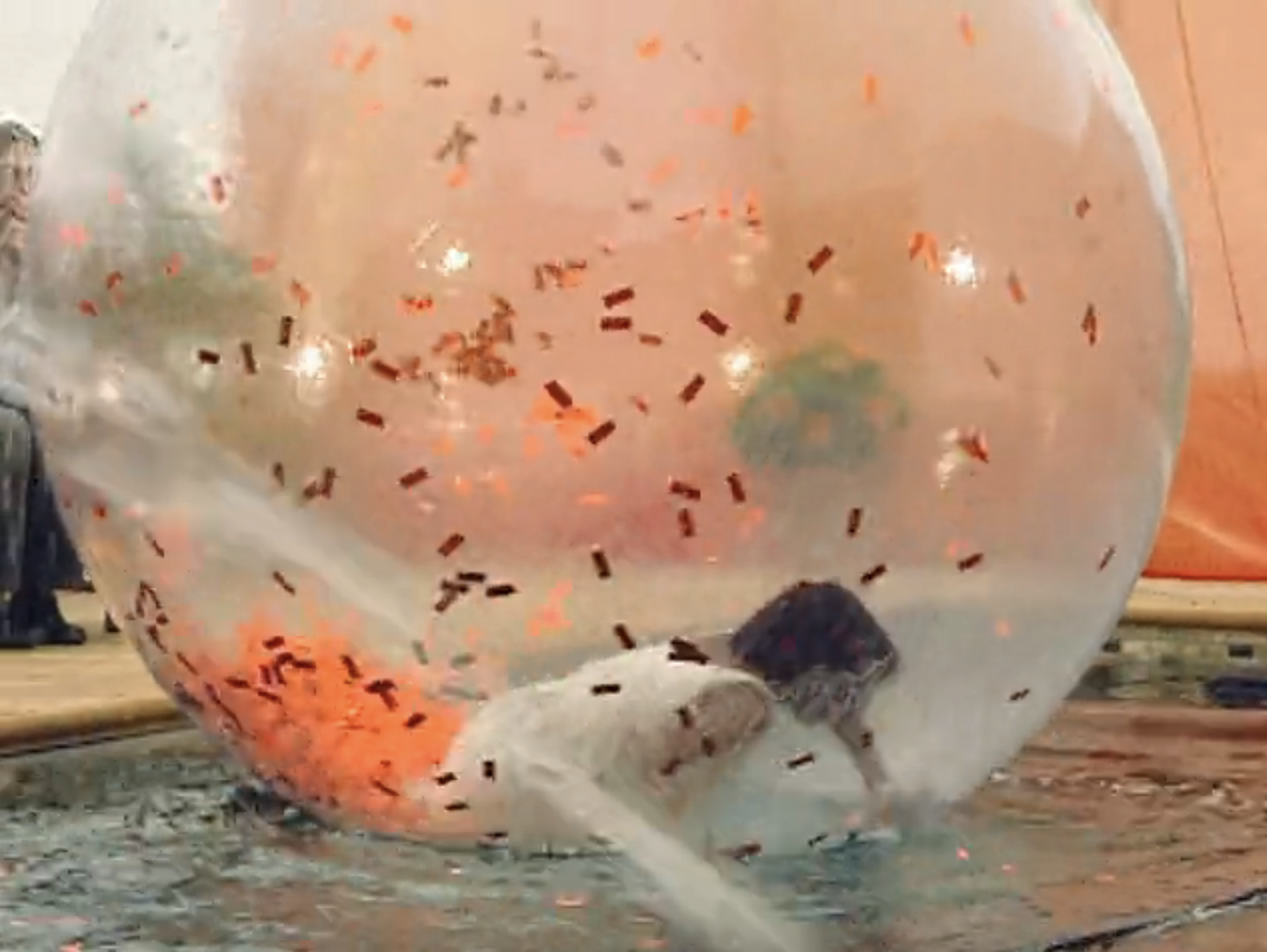 A contestant attempts to get out of the water while inside her bubble