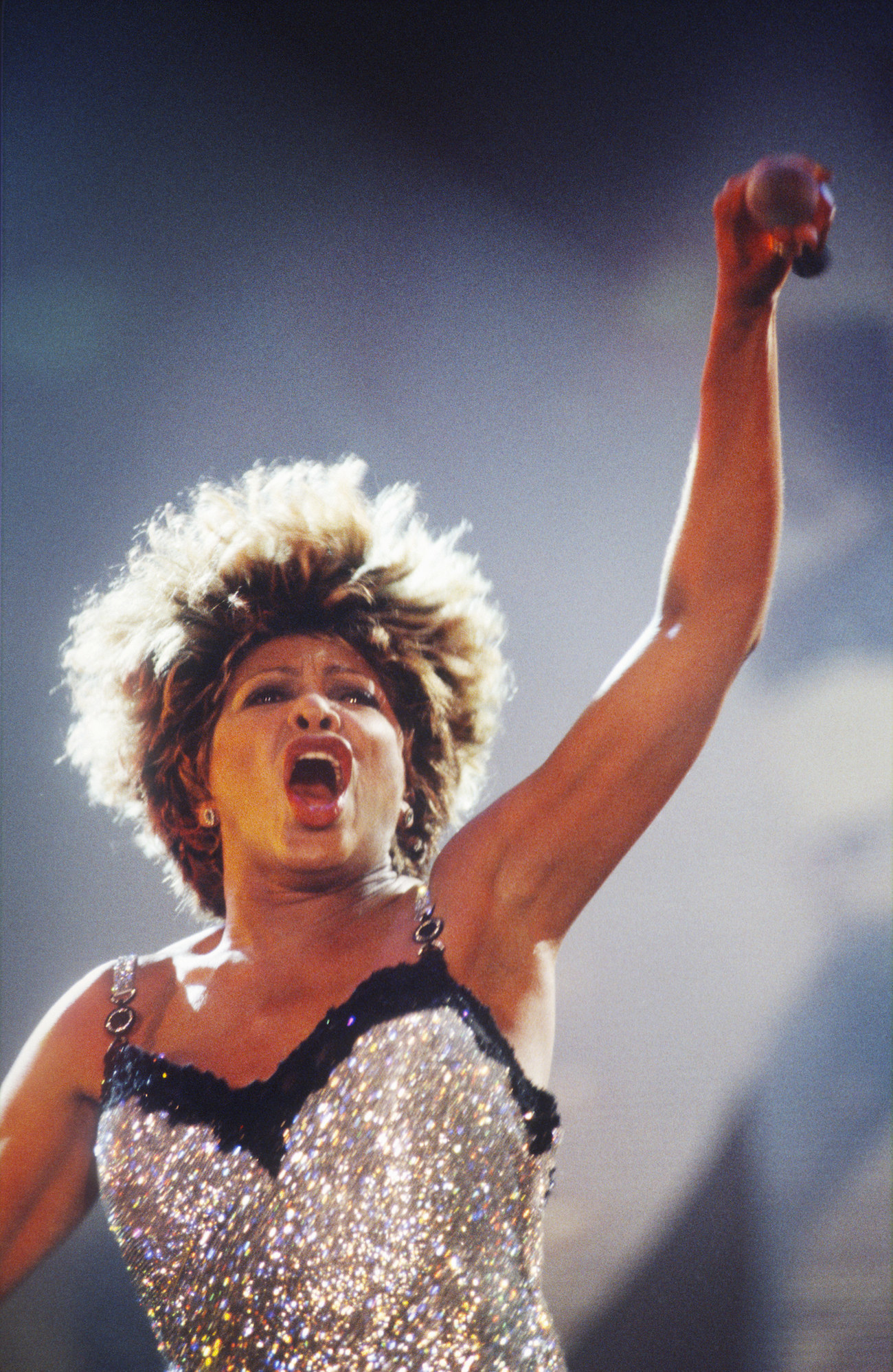 tina singing while pointing the mic to the crowd