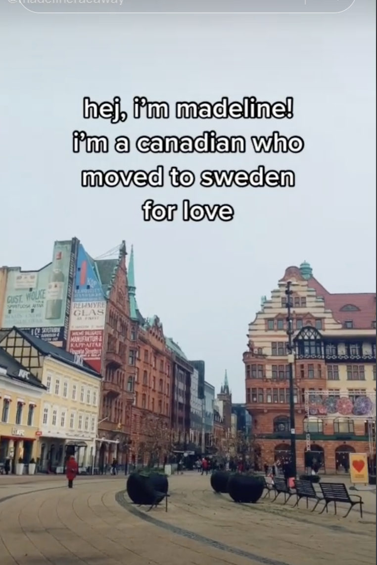 A TikTok screenshot from @madelineraeaway: a city street with Swedish architecture. Overlaying text reads "Hey, I'm Madeline! I'm a Canadian who moved to Sweden for love"