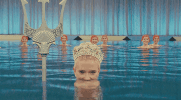 GIF of Scarlett Johansson from Hail, Caesar emerging from pool dressed as mermaid holding a trident