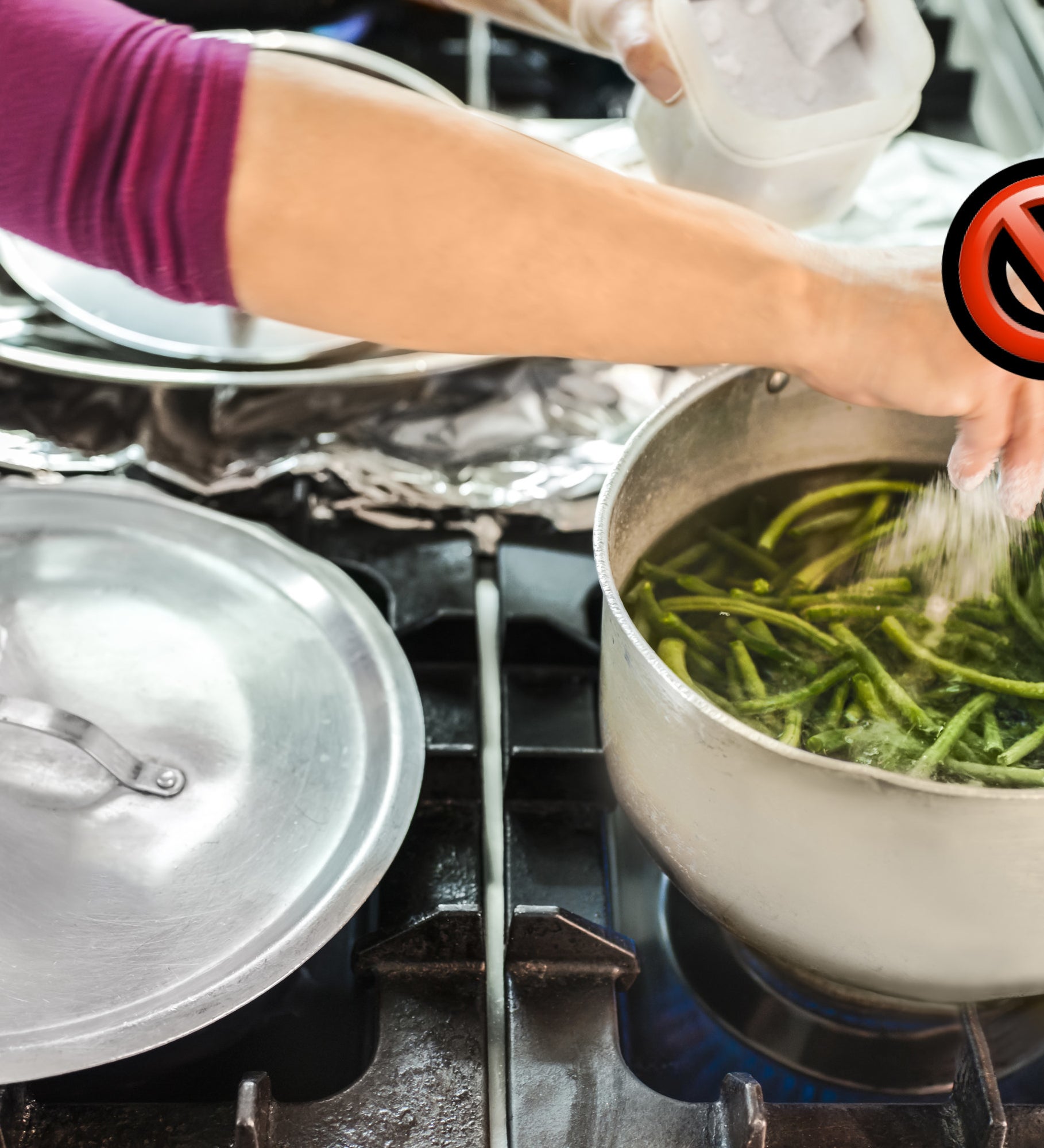 &#x27;no&#x27; sign while someone seasons a pot of boiling green beans with salt
