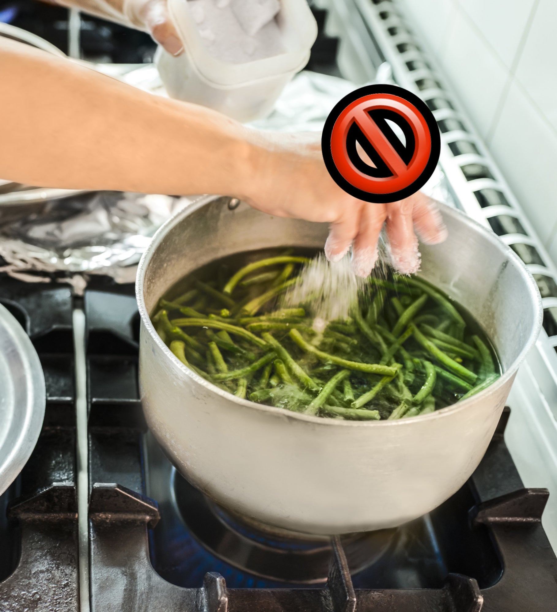 &#x27;no&#x27; sign while someone seasons a pot of boiling green beans with salt