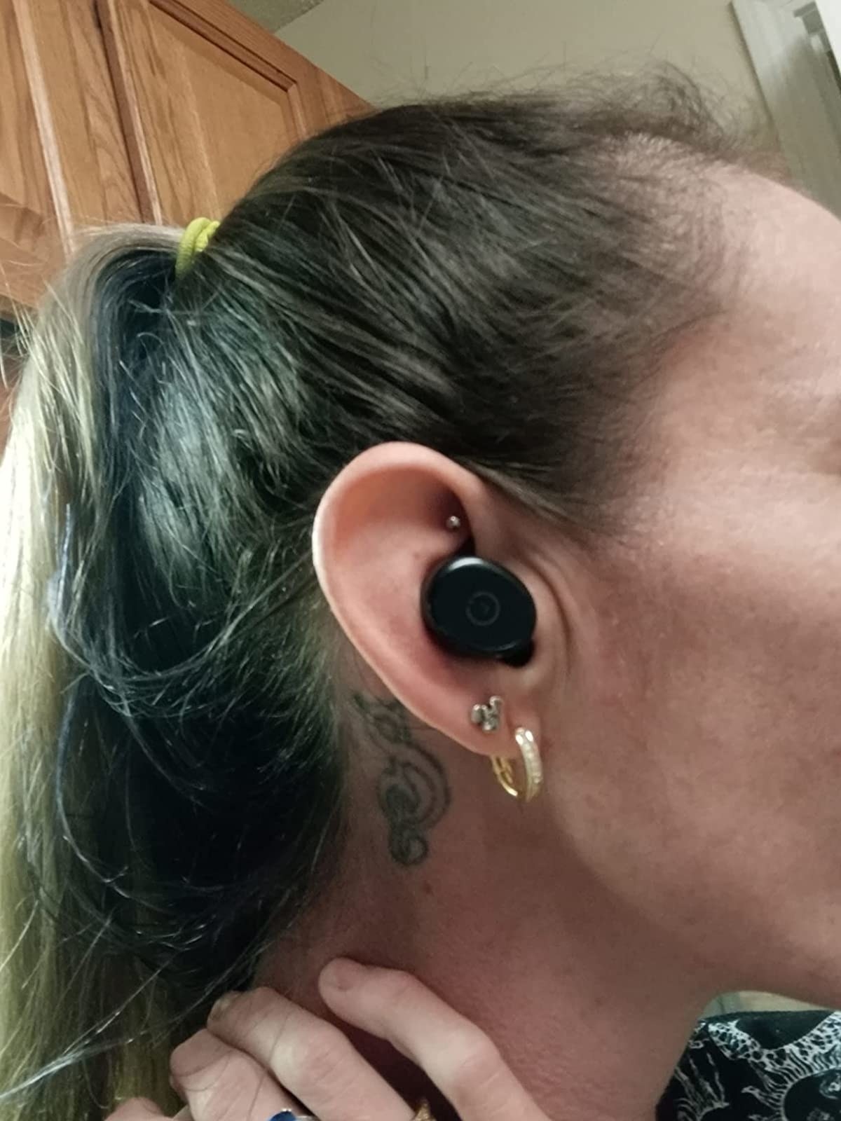 A reviewer with the black headphone in their ear