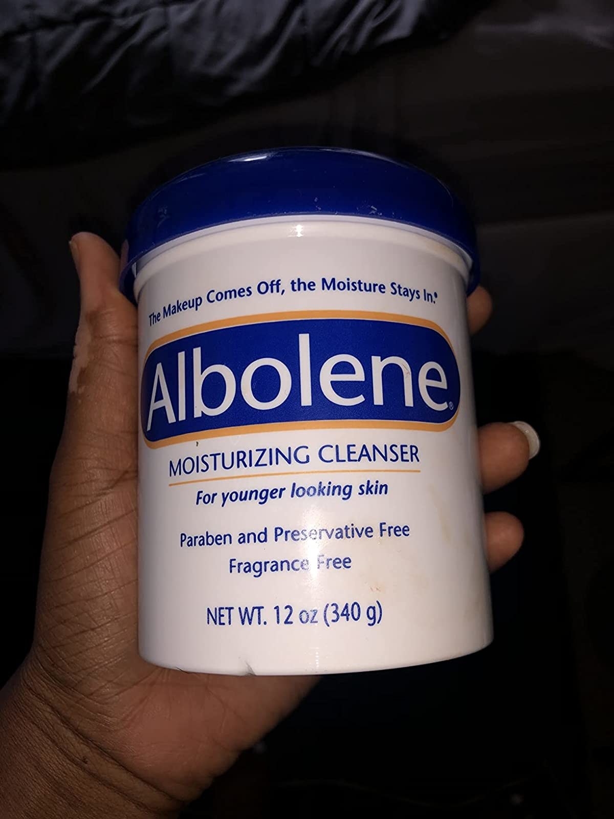 a reviewer holding the container of cleanser