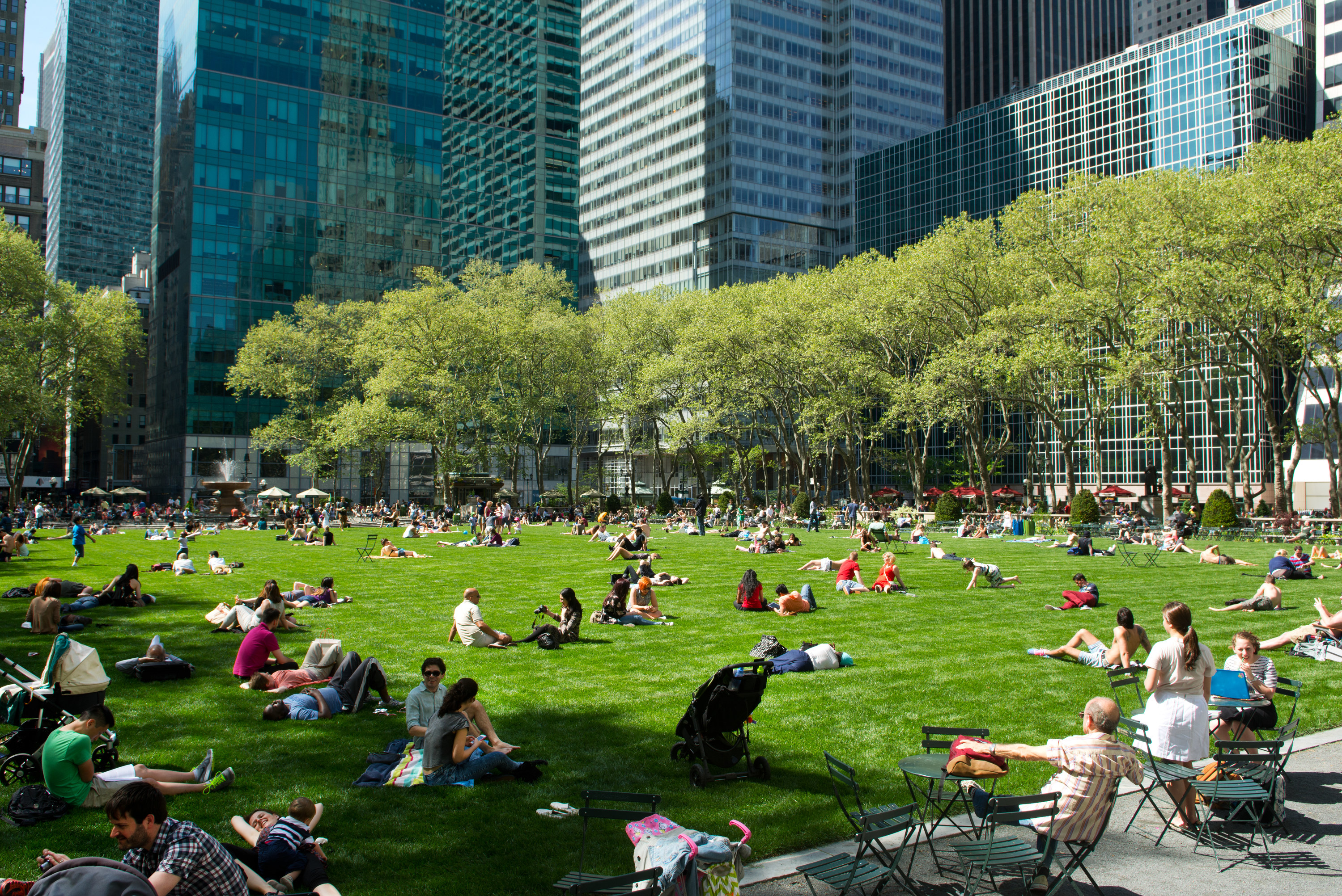 People sitting and lying on the grass in Bryant Park in New York City