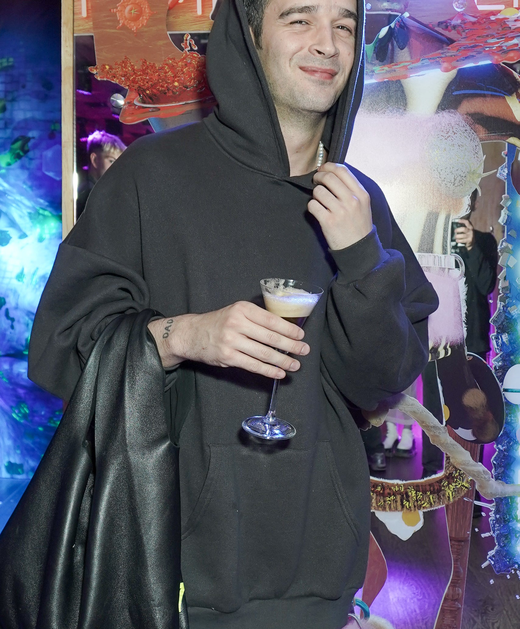 Matty in a hoodie and holding a drink