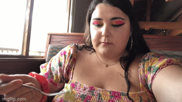 woman taking bite of salad and nodding approvingly