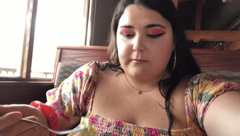 woman taking bite of salad and nodding approvingly