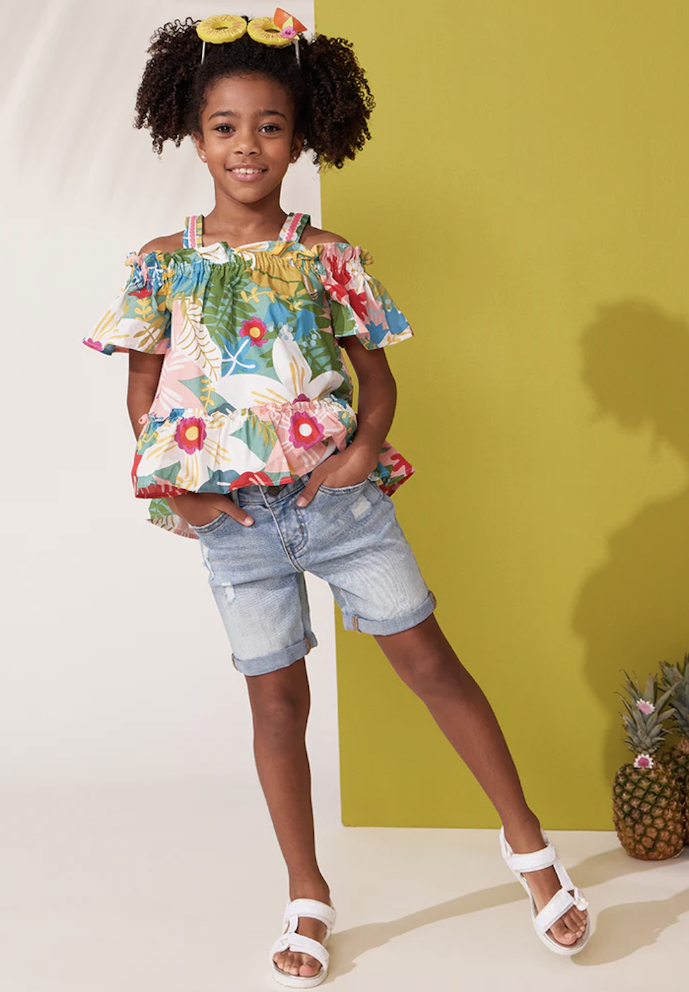 child in floral top and denim shorts