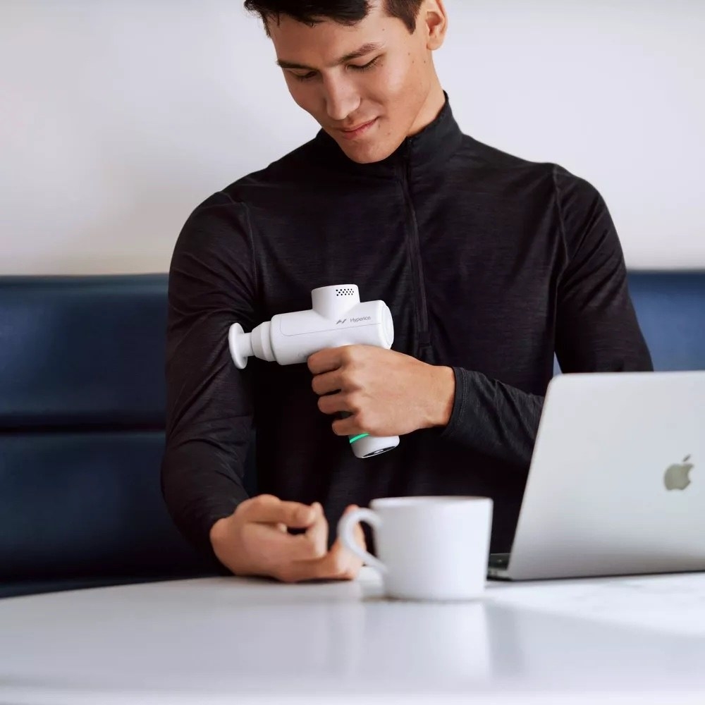 A model using a massage device on their arm