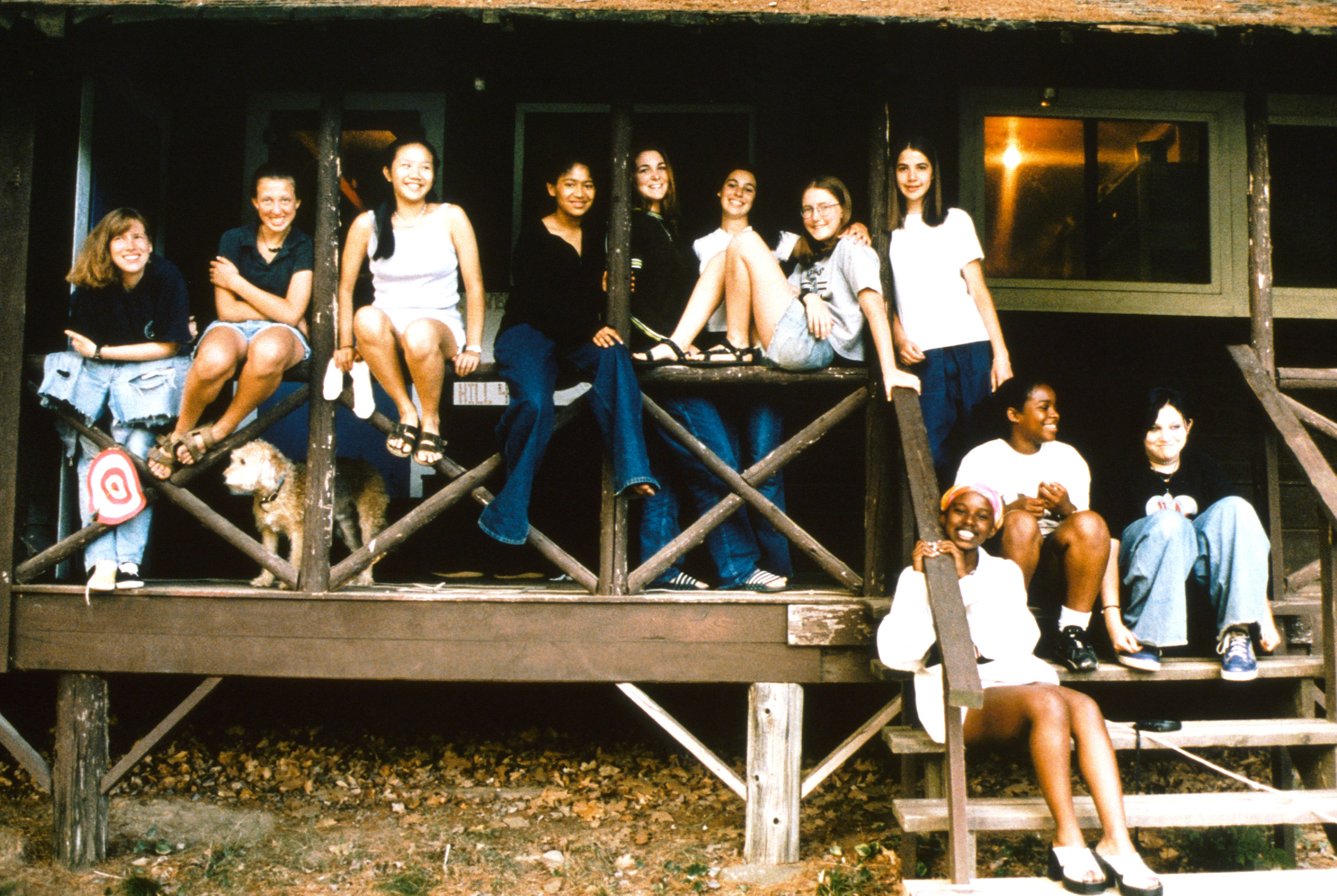 cast posing on the porch of a cabin