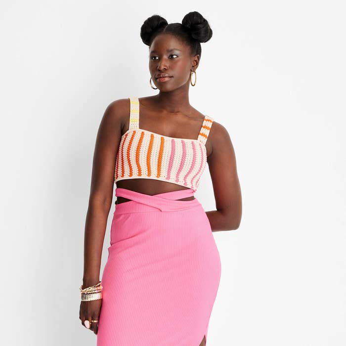 The model wearing the tank with a pink midi skirt