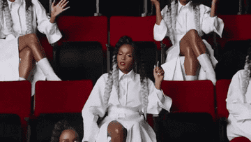 janelle in her music video sitting with clones of herself