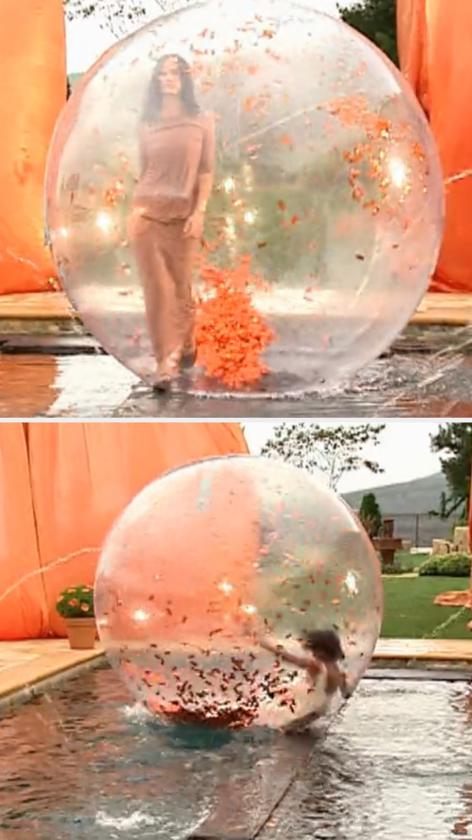 Contestants walk down the runway in plastic bubbles, one falls
