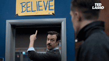 Ted Lasso points to his &quot;Believe&quot; sign
